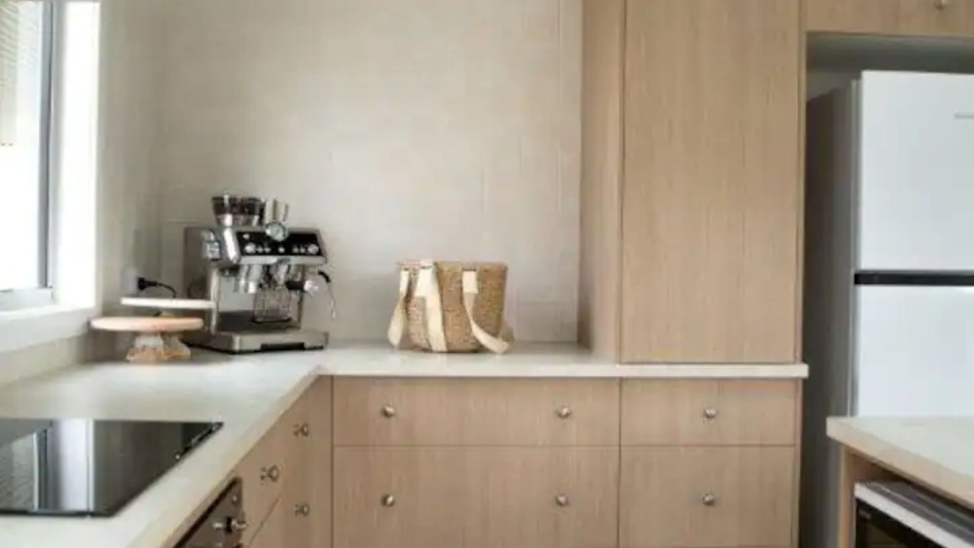 Una cocina con cafetera, bolso y refrigerador.