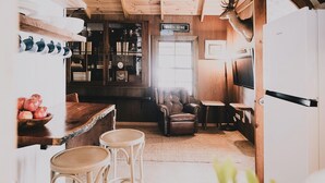 Una cocina acogedora con una barra de madera, un sillón de cuero y una cabeza de ciervo montada.