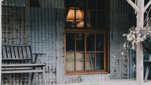 A rustic cabin with a wooden window, a bench, and a hanging plant. - La Baracca - Reconnect with the simple pleasures of life (Wandiligong)