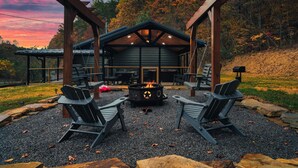 A cabin with a fire pit, two Adirondack chairs, and a pergola structure. - Relaxing Getaway~ K/Q Suites w/ Hot Tub & Fire Pit, Privacy, Great Location (Sevierville)