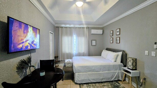 Een hotelkamer met een bed, een televisie, een bureau en een stoel.