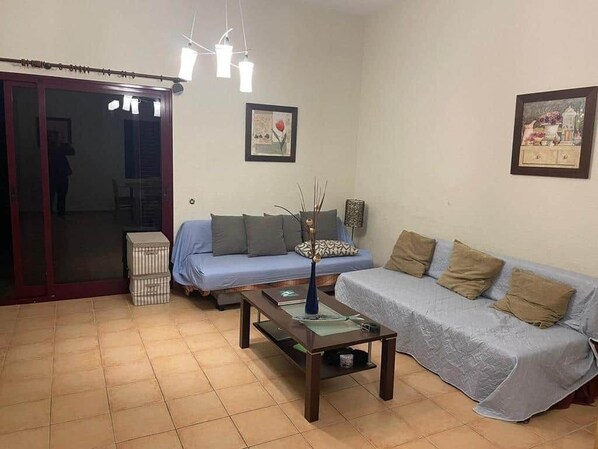 Cozy living space with a sofa, coffee table, and sliding door to an adjacent area.