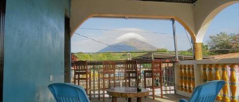 Un espace extérieur aménagé, abrité et doté de sièges, offrant une vue sur une montagne.