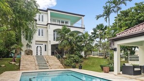 A two-story house with a swimming pool, surrounded by palm trees and a covered patio area. - Casa Bravo-Premier BEACH VIEW- Shacks Beach-Near Villa Montana Beach Resort (Isabela)