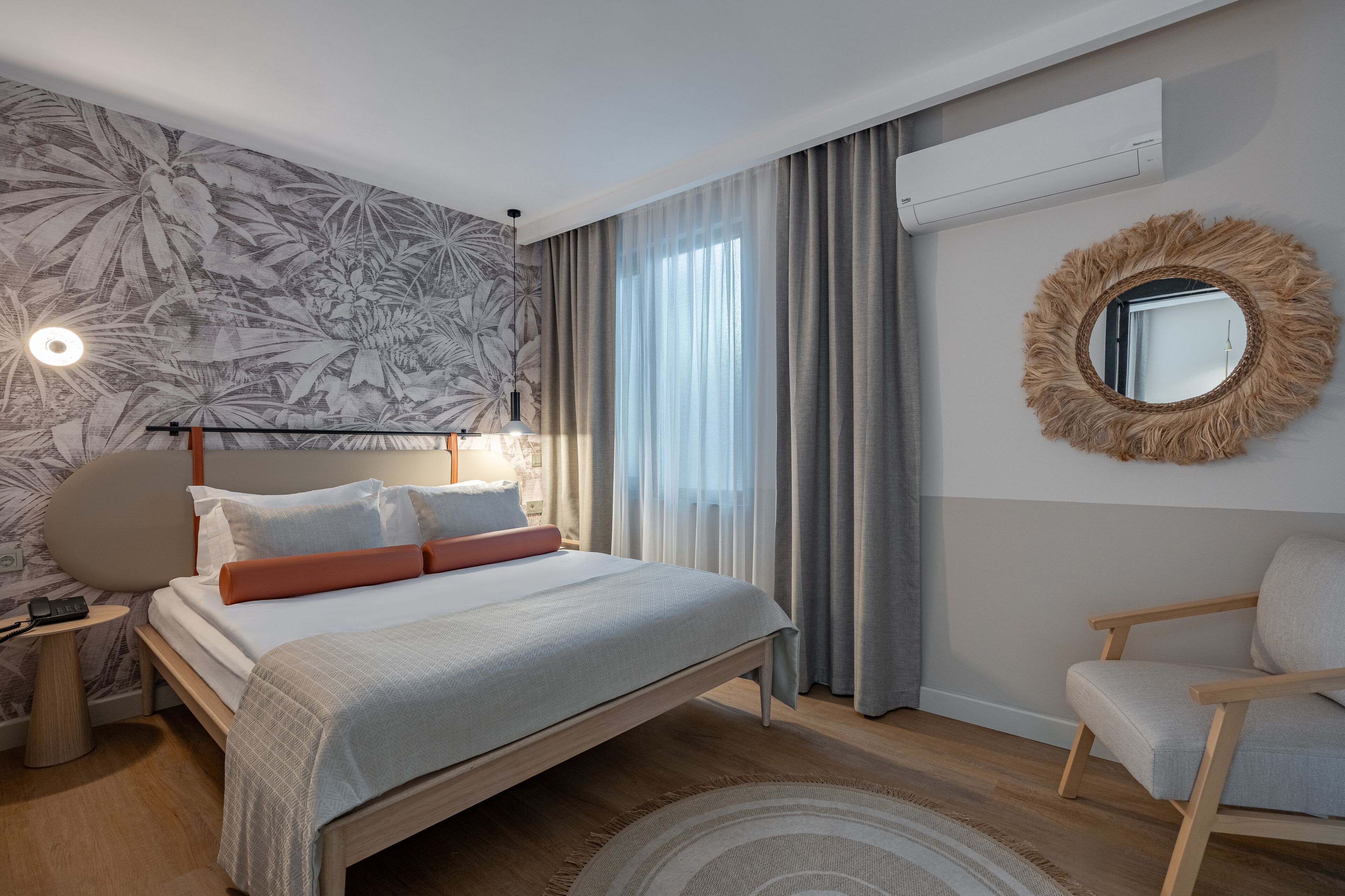 Een moderne slaapkamer met een bed, nachtkastje en stoel.