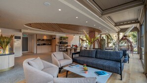 A modern hotel lobby with a seating area, a kitchen, and a large window providing natural light. - Oli Hotel And Suites (Konyaalti)