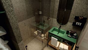 A modern bathroom with a green sink, a glass shower enclosure, and a large mirror.