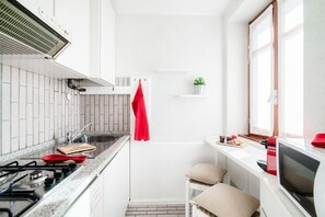 A compact kitchen with a gas stove, a sink, and a microwave. - Finestra sul Lago - My Home In Como (Cernobbio)