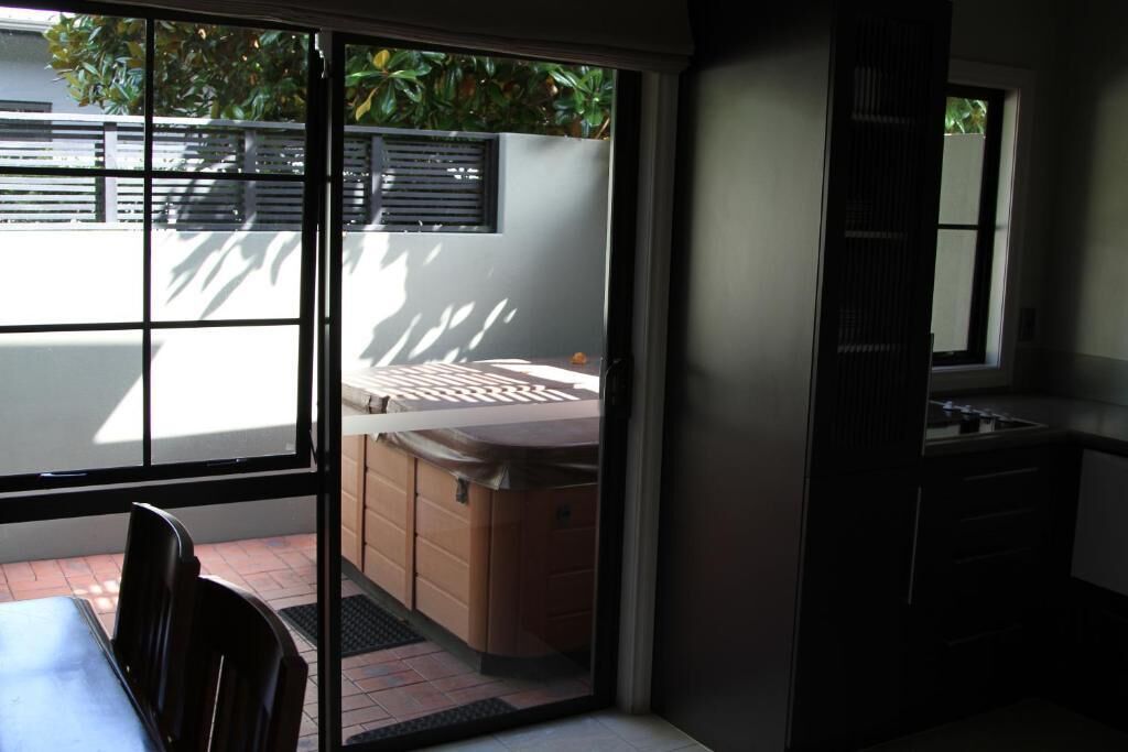 A modern kitchen with a sliding glass door leading to a patio area.