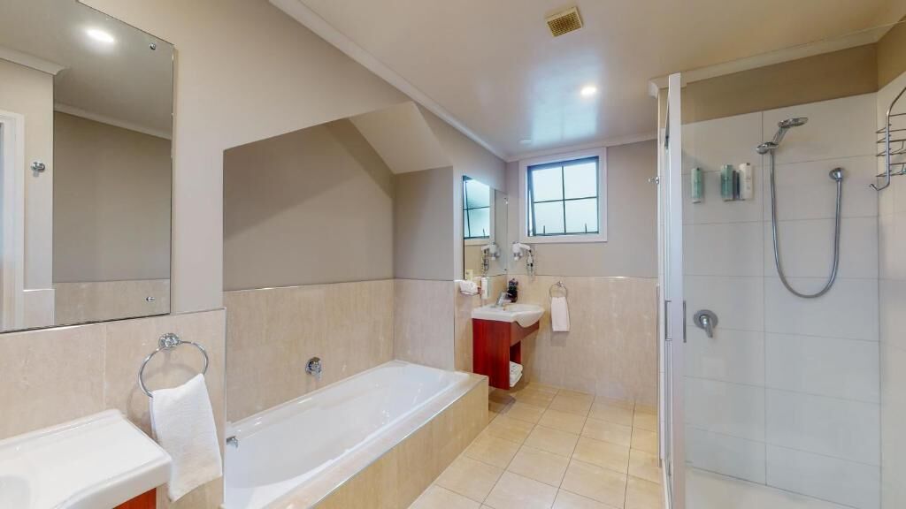 A modern bathroom with a bathtub, a shower, and a vanity.