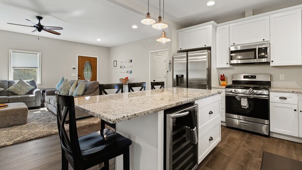 A modern kitchen with white cabinets, stainless steel appliances, and a granite countertop.