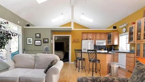 A compact living space with a kitchenette, a sofa, and a dining area. - Amazing Home...Large Space Yet Cozy (Kirkland)