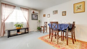 A dining area with a table set for four, surrounded by wooden chairs, a blue tablecloth, and a patterned rug. - Comfortable Alabama Apartment: Pets Welcome! (Jackson)