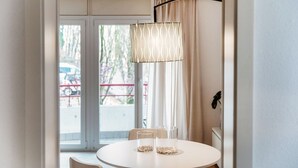 Un comedor con una mesa redonda, dos sillas y una lámpara colgante.