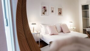 Un dormitorio con cama, mesitas de noche y decoración en la pared.