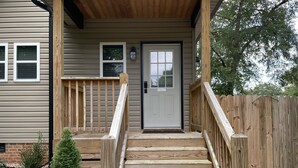 A wooden staircase leading to a front door with a 'No Smoking' sign, a small tree, and a wooden fence. - Cozy Guest House located near downtown! 







































 (Hickory)