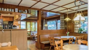 A restaurant interior with wooden furniture, a bar area, and large windows. - landgasthaus waldhorn (Forbach)