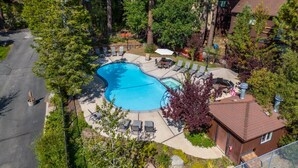 A residential area with a swimming pool surrounded by lounge chairs and a barbecue area.