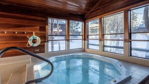 A hot tub with a wooden interior and large windows.