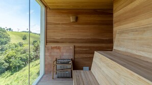 A wooden interior with a large window, a bench, and a fireplace. - Vista Deslumbrante e Alto Padrão com 4 Suites, Piscina Aquecida e Sauna (Santo Antônio do Pinhal)