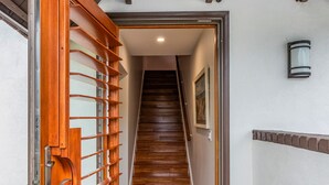 A wooden staircase leading to a room with a welcome mat that reads "this is our happy place."