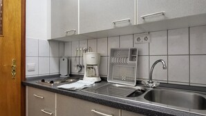 A modern kitchen with a stainless steel sink, a coffee maker, and a kettle. - Cozy apartment in Goslar OT Hahnenklee with WiFi (Goslar OT Hahnenklee)