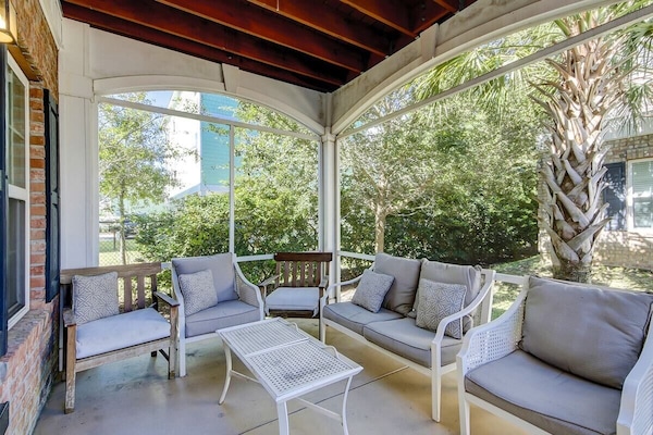 Relaxing screened patio with comfy seating and greenery for private outdoor time