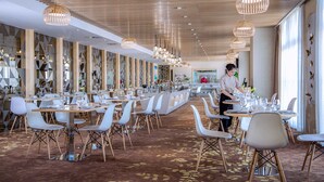 A modern restaurant with a long counter, white chairs, and hanging wooden light fixtures. - Shijiazhuang Nuohuating Hotel (Shijiazhuang)