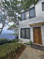 Uma casa moderna de dois andares com uma grande janela e porta de madeira.