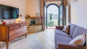 A living room with a fireplace, a television, and a sofa.