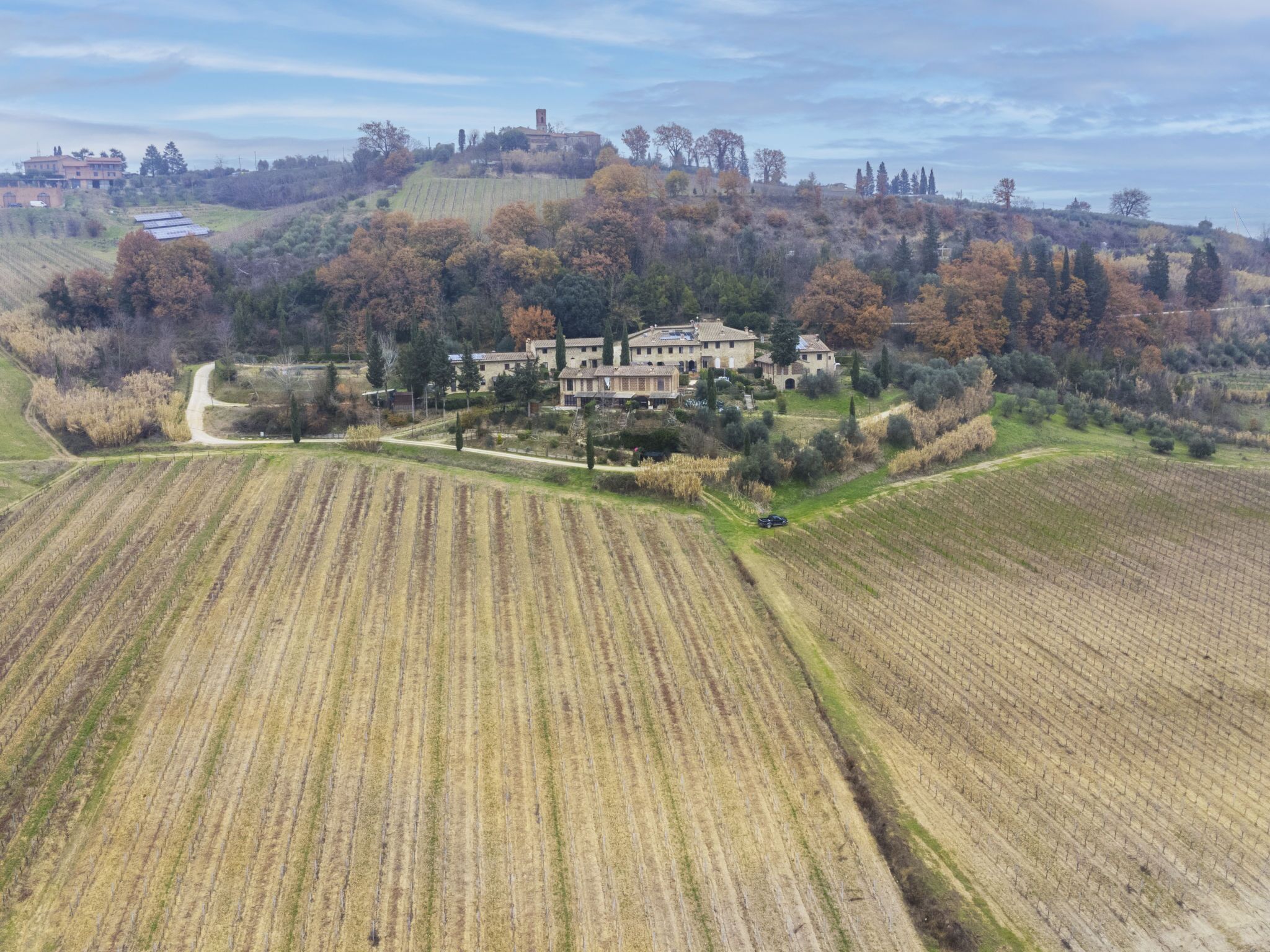 Una extensa propiedad con varios edificios rodeada de campos agrícolas amplios y un paisaje montañoso.