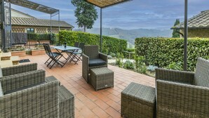 An outdoor patio with wicker furniture, a table, and chairs.