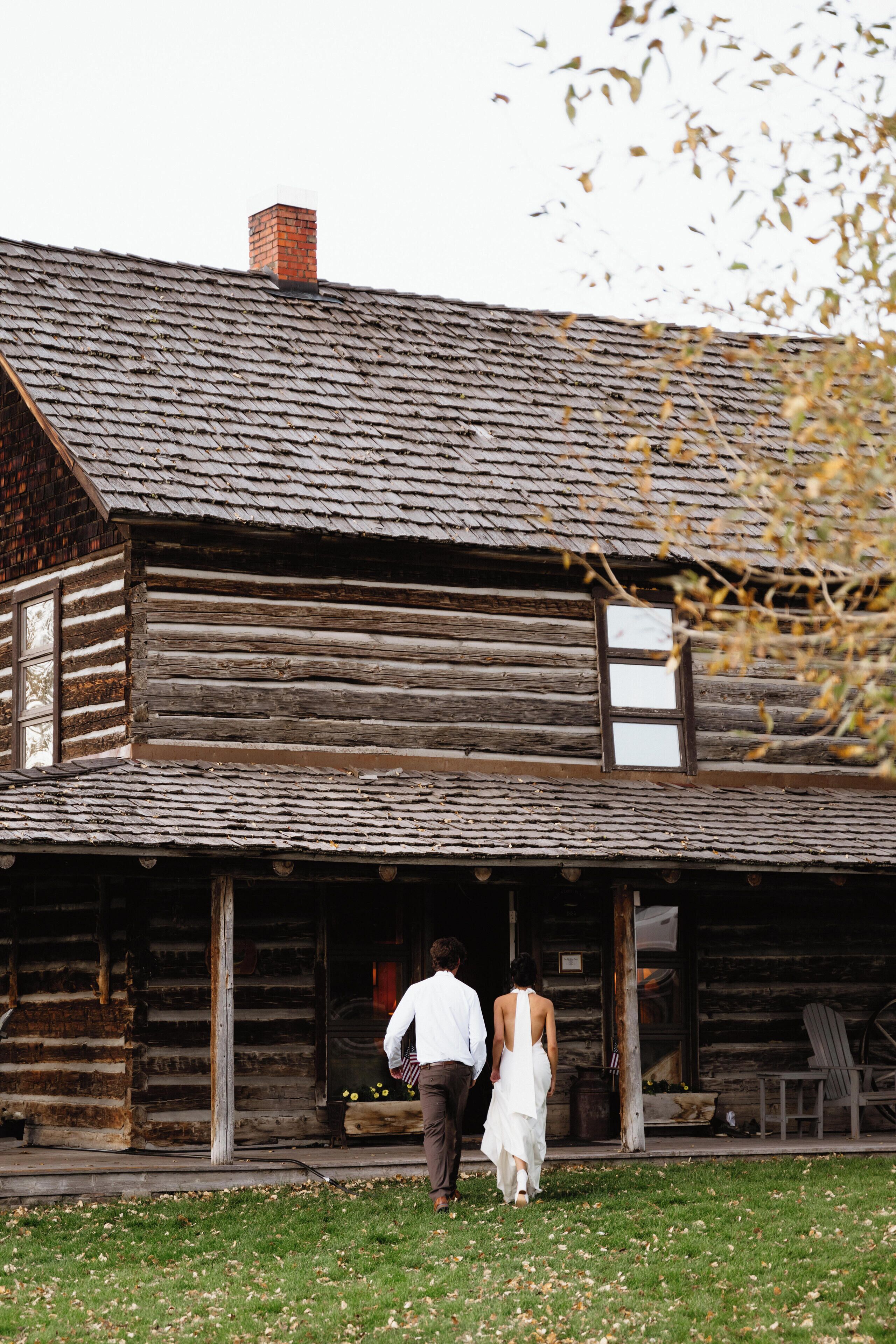 A rustic log cabin with a porch and a chimney.