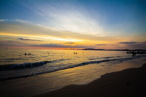 A beach at sunset with calm waters, a pier, and distant mountains. - KRABI MORE HOTEL (Krabi)