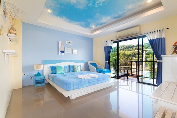 A modern bedroom with a large bed, a balcony with a view, and a ceiling with a sky design.