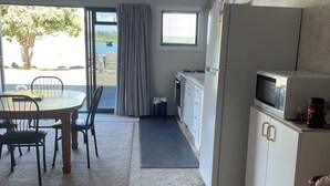 A compact living space with a dining area, kitchenette, and a view of the outdoors.