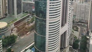 A high-rise building with a modern architectural design, featuring a cylindrical shape and reflective glass facade. - Yutai hotel-Style Apartment (Shenzhen)