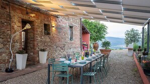 An outdoor dining area with a brick wall, a table set for four, and a view of the landscape. - Beautiful private villa for 11 people with WIFI, A/C, private pool, TV, patio and panoramic view (Bobolino)