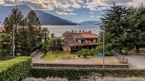 A house with a tiled roof, surrounded by greenery and a lake. - Cristina by Interhome (Gravedona)