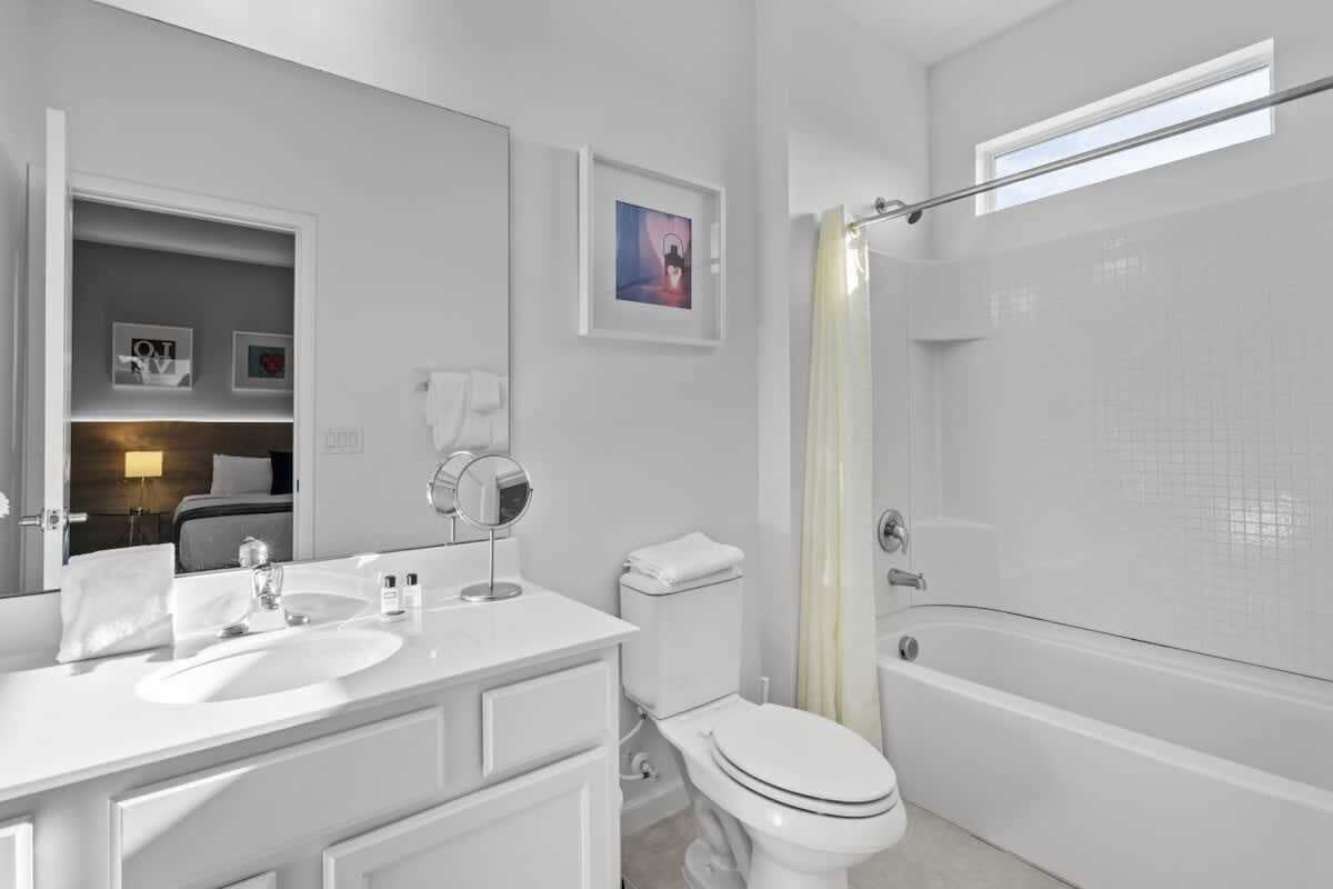 Une salle de bain moderne avec un lavabo, des toilettes et une baignoire.