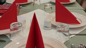 A dining table set with red napkins, clear glassware, and silverware. - Room in Guest Room - Single Room in City Hotel in the Centre of Rastatt (Rastatt)