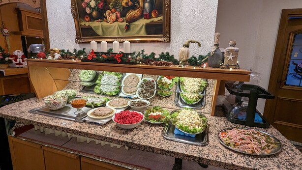 A buffet counter with various food items and a painting above it. - Room in Guest Room - Single Room in City Hotel in the Centre of Rastatt (Rastatt)