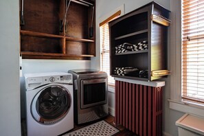 Une buanderie équipée d’un lave-linge, d’un sèche-linge et d’une étagère.