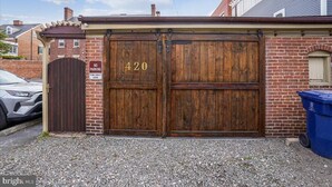 A wooden double garage door with the number 420, a 'No Parking' sign, and a 'Tow-Away Zone' sign. - Victorian on Washington king bed near King St Hot Tub (Alexandria)