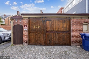 A wooden double garage door with the number 420, a 'No Parking' sign, and a 'Tow-Away Zone' sign. - Victorian on Washington king bed near King St Hot Tub (Alexandria)