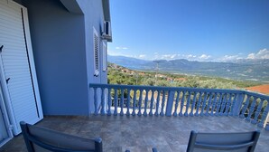 A balcony with two chairs, a view of mountains, and a clear sky. - Captivating and Spacious 2-Bed House in Vranovici (Vranovici, Kotor)