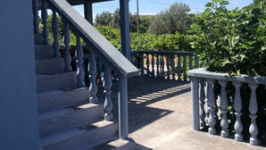 A staircase with balustrades leading to a covered area, surrounded by greenery and a clear sky. - Captivating and Spacious 2-Bed House in Vranovici (Vranovici, Kotor)