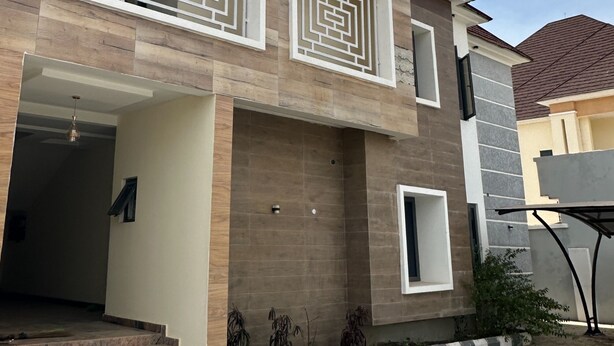 Une maison moderne avec une façade en bois, une entrée bien visible et une petite fenêtre.