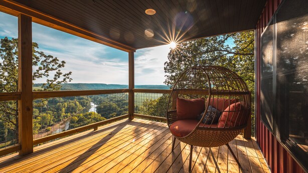 A wooden deck with a hanging chair overlooking a scenic landscape. - Cozy Cabin In The Sky, with direct access to public hunting, fishing access. (Dixon)