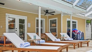 A poolside area with lounge chairs, a ceiling fan, and a covered patio. - 4BR Heated Pool|12min to Beach|Gameroom|King beds (Clearwater)